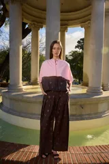 Pantalón marrón de corte ancho y holgado, con delicados bordados de flores en toda la prenda. Cuenta con cierre frontal y cintura con botones.