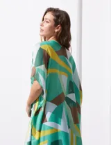 Kimono tejido de poliéster con estampado geométrico en tonos verde, amarillo, blanco y marrón. Presenta mangas amplias tipo japonesa y terminación de ruedo con borlas.