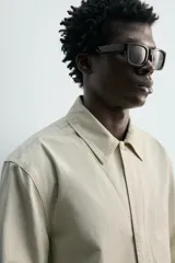Sobrecamisa de corte regular fit en color beige, confeccionada en popelín de algodón. Cuenta con cuello solapa, manga larga con puño abotonado, bolsillos ocultos en las costuras de la cadera y cierre frontal con botonadura oculta.