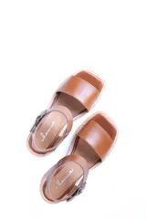 Sandalias de cuero color tostado con tira ancha sobre los dedos, tira al tobillo con hebilla y taco de madera.