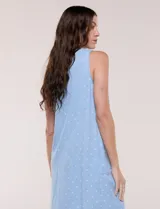 Vestido corto azul con estampado de lunares blancos, silueta evasé, sin mangas y escote en V con bolsillos laterales.