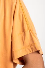 Remerón color naranja de algodón peinado con calce oversize y mangas cortas con dobladillo.