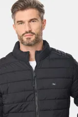 Campera de abrigo gris oscuro, capitoneada, con cuello alto y capucha desmontable. Cierre frontal con cremallera y bolsillos laterales con cierre. Logo bordado en el pecho.