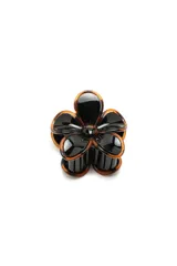 Broche para el pelo con forma de flor, realizado en material plástico con acabado brillante en color negro y bordes en tono carey.