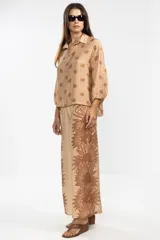 Camisa de manga larga color rosa con rayas verticales rojas y estampado de flores rojas. Con cuello camisero, puños elastizados y lazos regulables en los costados del ruedo.