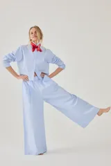 Pijama de algodón a rayas celestes y blancas, compuesto por una camisa de manga larga con botones y un pantalón largo de corte ancho.