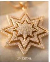Collar de bronce con baño dorado, con cadena fina de eslabones y un dije colgante en forma de estrella de ocho puntas pavimentada con circonitas.
