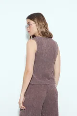 Top cruzado sin mangas color gris oscuro, con escote en V profundo y lazo ajustable lateral. La tela presenta una textura acanalada o plisada.