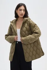 Campera acolchada de color negro con diseño capitoneado de ondas, manga larga, capucha integrada y cierre frontal con botones a presión.