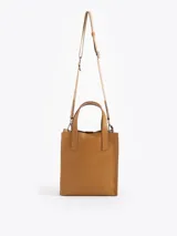 Cartera tipo tote pequeña de cuero color tostado, con doble asa superior y herrajes metálicos plateados en forma de llama en la base de las manijas. Presenta el logo de la marca estampado en la parte inferior frontal.