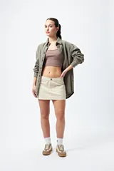 Minifalda color beige estilo cargo, de tiro bajo y corte recto, con bolsillos laterales.