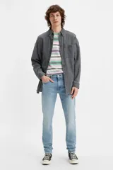 Jean de corte slim taper con tiro bajo, confeccionado en denim elástico de tono celeste claro con efecto desgastado.
