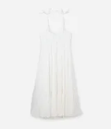 Vestido midi blanco confeccionado en tejido de viscosa con hilo metalizado, breteles finos de moña, escote v, busto marcado y volados en la pollera.