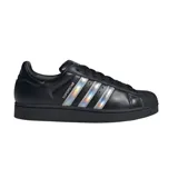 Championes Adidas modelo Superstar, color negro con las icónicas tres tiras laterales en acabado iridiscente y puntera de goma clásica.