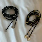 Gargantilla negra con pelotitas doradas y dijes redondos dorados.