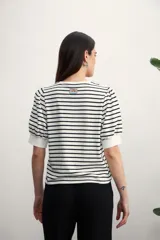 Remera de algodón con estampado de rayas horizontales en color verde claro sobre fondo blanco, con mangas cortas abullonadas y puños lisos.