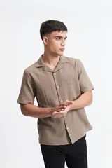 Camisa de manga corta color crema con textura, cuello clásico y calce regular.