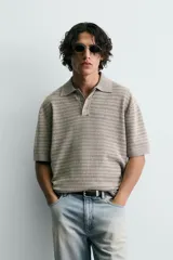 Polo relaxed fit de punto tejido en hilatura con mezcla de algodón y textura rizada, color gris con diseño a rayas sutiles, cuello solapa con cierre frontal de botonadura y manga corta con acabados en rib.