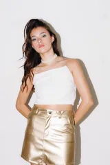 Minifalda dorada de cuerina con cierre, botón y bolsillos delanteros.