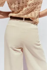 Pantalón de jean color crudo, de tiro alto, corte wide leg cropped y cinturón marrón.