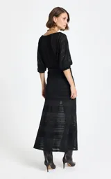 Pollera midi de punto color negro, con diseño calado y franjas horizontales de diferentes texturas. Presenta un corte entallado que se ensancha ligeramente hacia el ruedo.