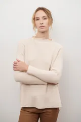 Polera de tejido de punto en color beige, con cuello alto y mangas largas con puños acanalados.