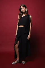 Top negro asimétrico con un hombro descubierto y manga con volado de red.