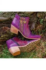 Bota corta de cuero violeta con diseño pintado a mano, taco cuadrado de madera, doble cierre lateral con tiradores metálicos y suela con estampado de leopardo.