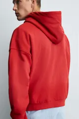 Sudadera roja con capucha, cierre frontal con cremallera, bolsillos tipo canguro y corte relaxed boxy fit.