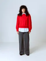 Sweater rojo de punto con cuello redondo y mangas largas abullonadas, con puños y dobladillo acanalados.