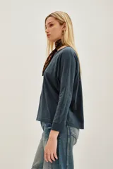 Remera azul de algodón peruano con textura jaspeada, de moldería holgada y buena caída, con mangas largas que se ajustan hacia la muñeca y se ensanchan debajo del brazo.