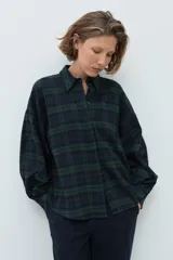 Camisa de manga larga con estampado de cuadros en tonos verde y azul marino, cuello clásico y cierre frontal con botones.