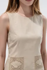 Vestido corto blanco de viscosa, sin mangas, con cuello redondo a la base y bolsillos frontales con apliques bordados.