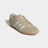 Championes Adidas modelo Tokyo de corte bajo y diseño retro. Confeccionados en gamuza color beige con las icónicas tres tiras laterales en color crema y suela de caucho natural.