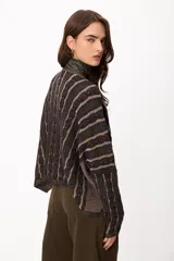 Sweater de punto con diseño de rayas verticales en relieve y textura trenzada, color terracota y beige. Presenta cuello redondo, corte holgado y diseño cropped.