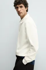 Sudadera polo azul marino de corte regular fit, confeccionada en tejido técnico interlock de algodón con elasticidad. Presenta cuello solapa, cierre frontal de cremallera y manga larga con acabados en rib.