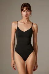 Body negro con tirantes finos, escote en V pronunciado y corte ajustado al cuerpo, con detalles bordados sutiles.