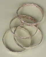 Esclava rígida de diseño artesanal con textura irregular y acabado metálico, ideal para uso diario.