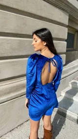 Vestido corto azul eléctrico de terciopelo, con mangas largas abullonadas y falda cruzada con frunces.