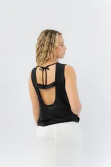Top sin mangas de lino metalizado con acabado brillante, escote cerrado y espalda abierta con lazo ajustable.