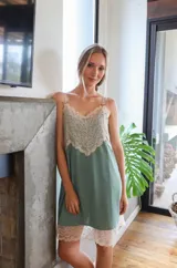 Camisón de algodón color verde seco con escote en V y ruedo decorados con puntilla de encaje en tono crema. Posee breteles finos ajustables y corte holgado.