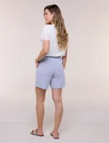 Short de algodón color celeste con sutiles rayas blancas, de silueta holgada, pierna recta y pretina fruncida con elástico y cordón de ajuste.