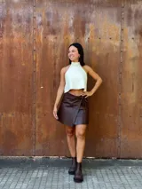 Minifalda tipo pareo confeccionada en cuero color chocolate, con diseño cruzado y cierre mediante tiritas laterales ajustables.