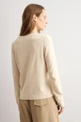 Sweater clásico de punto color beige, de cuello redondo y manga larga con diseño ajustado.