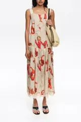 Vestido midi con vuelo en el bajo, de corte recto con tirantes anchos y escote cuadrado, confeccionado en mezcla de lyocell. Presenta un estampado artístico integral con figuras humanas en tonos rojos y naranjas sobre fondo crudo, además de costuras visibles decorativas.