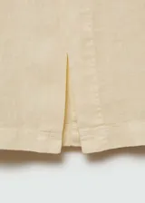Falda midi de corte recto confeccionada en lino. Presenta tiro medio, trabillas en la cintura, cierre oculto de botón, gancho y cremallera, detalle de abertura frontal y dos bolsillos de parche en la parte posterior.