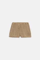 Shorts de tejido rústico en tonos tierra con tiro medio, cintura elástica con cordón de ajuste y detalles de ribetes a tono en los bajos.