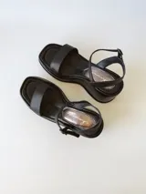 Sandalias negras de cuero con plataforma y pulsera al tobillo.