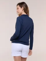 Campera liviana blanca de silueta entallada con protección solar UPF 50, cuello alto y cierre frontal completo. Cuenta con mangas largas y bolsillos laterales.