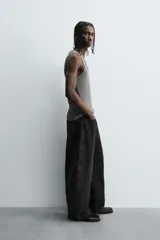 Camiseta sin mangas (tank top) negra, de corte slim fit, con cuello redondo de efecto doble.